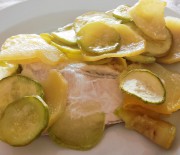 Filetti di pesce in un letto di patate e zucchine